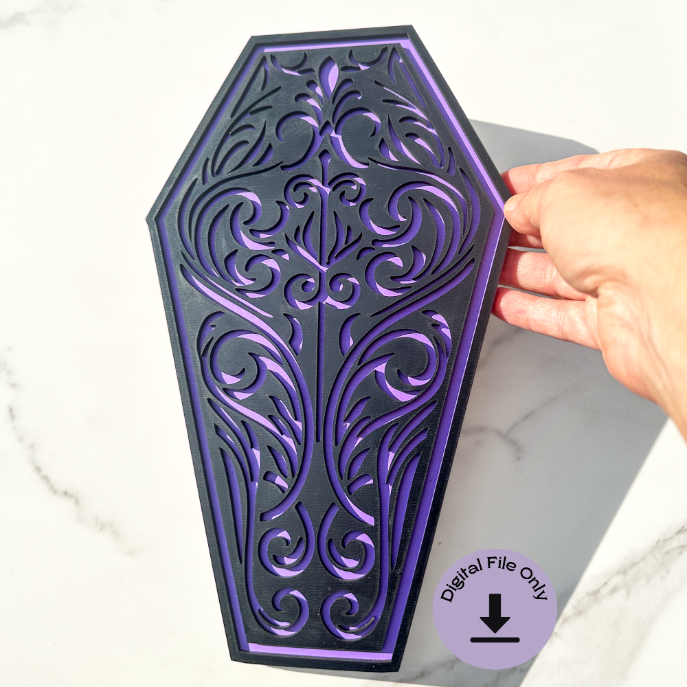An intricate gothic coffin laser cut design displayed on a light wood background. The coffin shape features an ornate filigree pattern, optimized for laser cutting in wood, acrylic, and MDF. Includes SVG, DXF, and AI file formats for CNC and laser engraving projects. Digital file only—no physical item.
