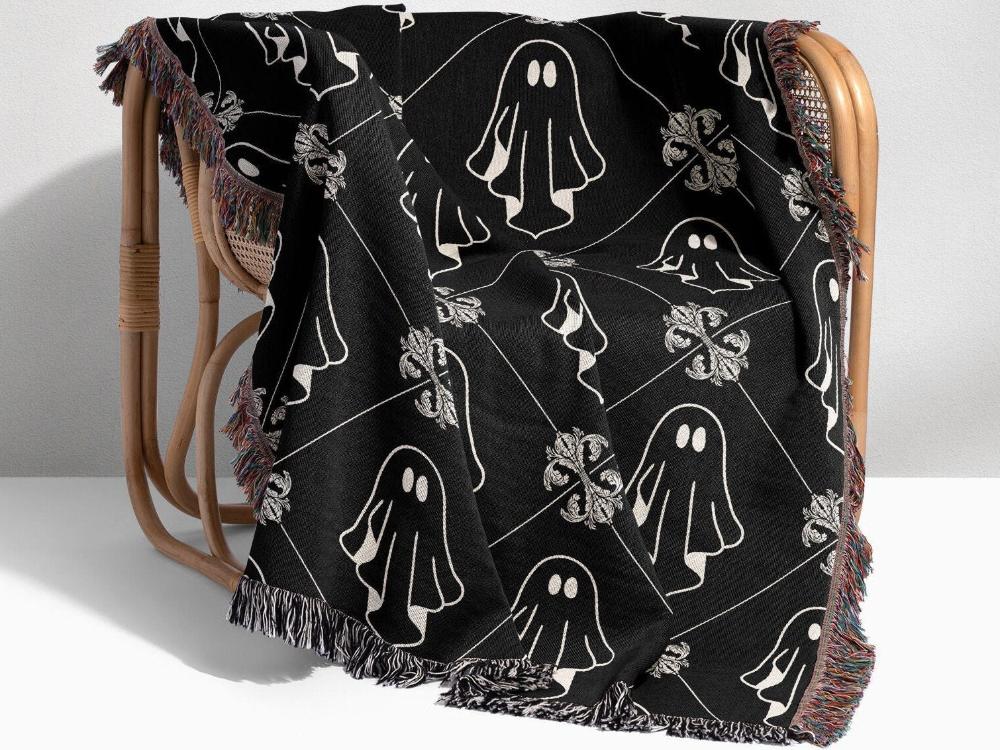 Woven Ghost blanket on a chair in black and white with fringe